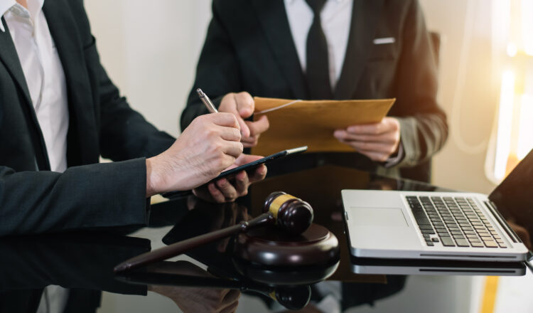 Business and lawyers discussing contract papers with brass scale on desk in office. Law, legal services, advice,  justice and law concept .