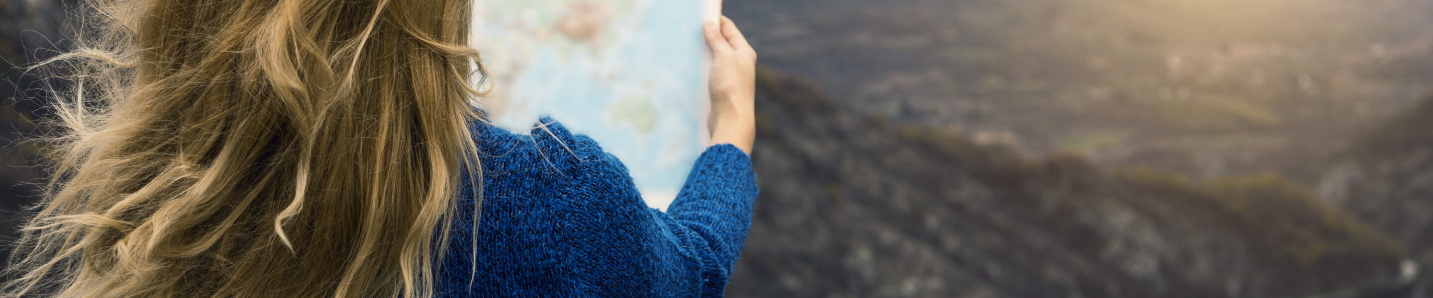 Traveler with world map at mountain