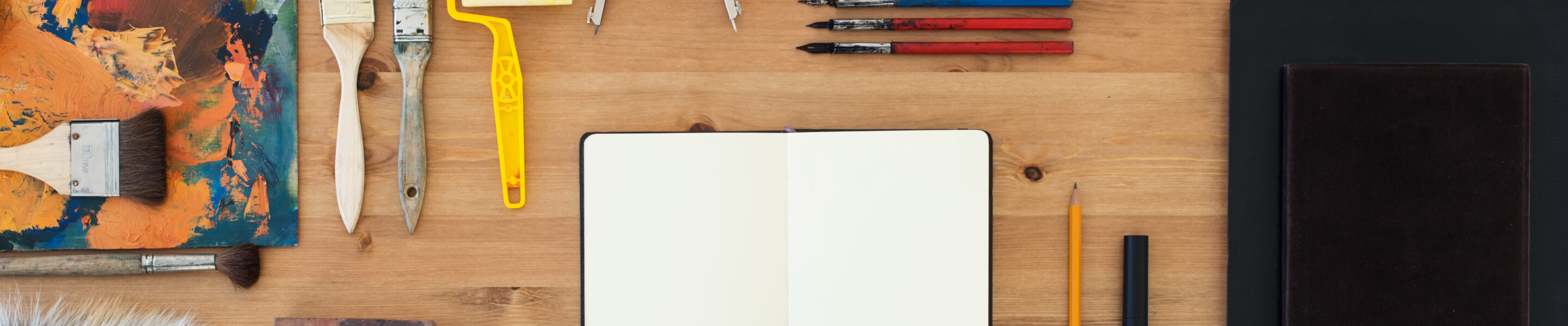 Painter workplace top view. Wooden table of an artist with art tools for drawing