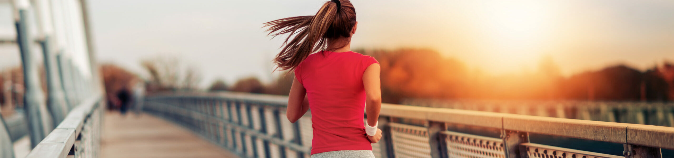 Young fitness woman running over the bridge.Sports, fitness, health and lifestyle concept.