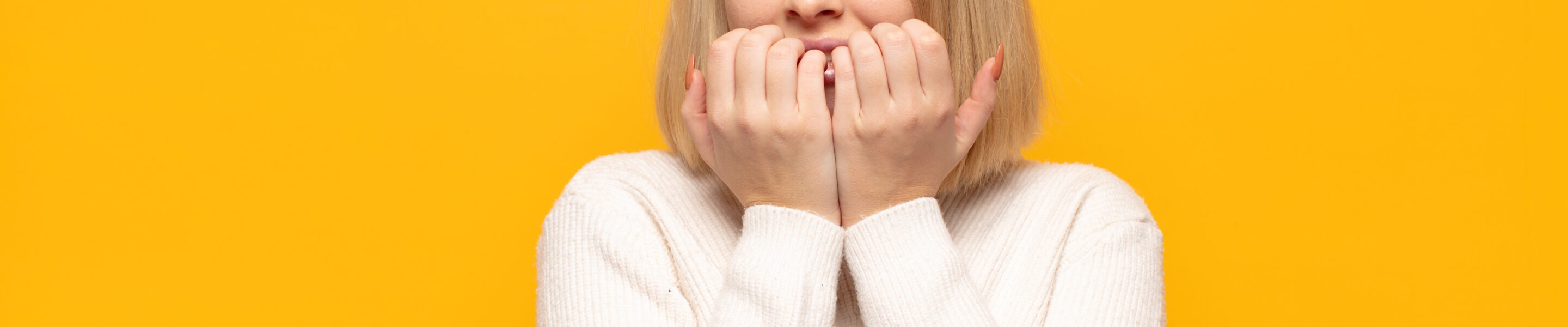 blonde woman looking worried, anxious, stressed and afraid, biting fingernails and looking to lateral copy space