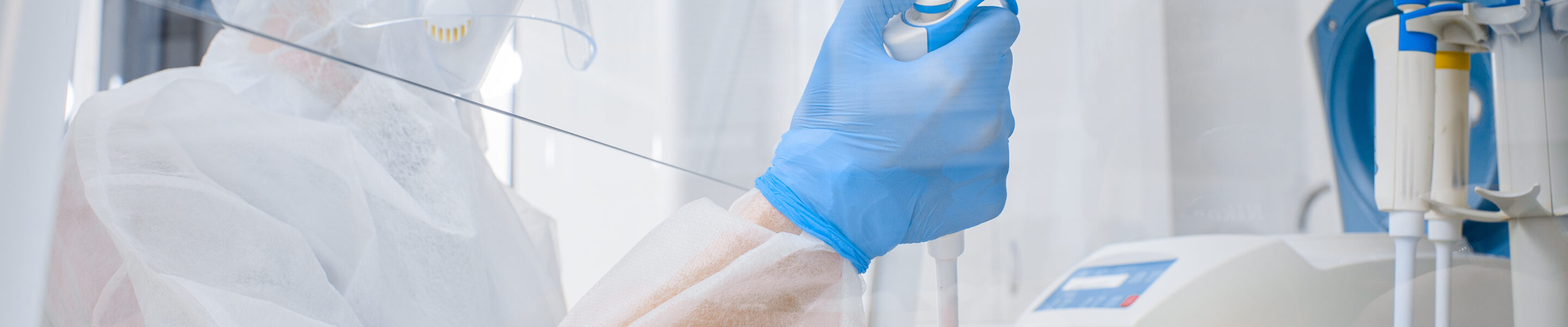 Laboratory assistant in a protective suit and mask in a modern prc laboratory. Dna test