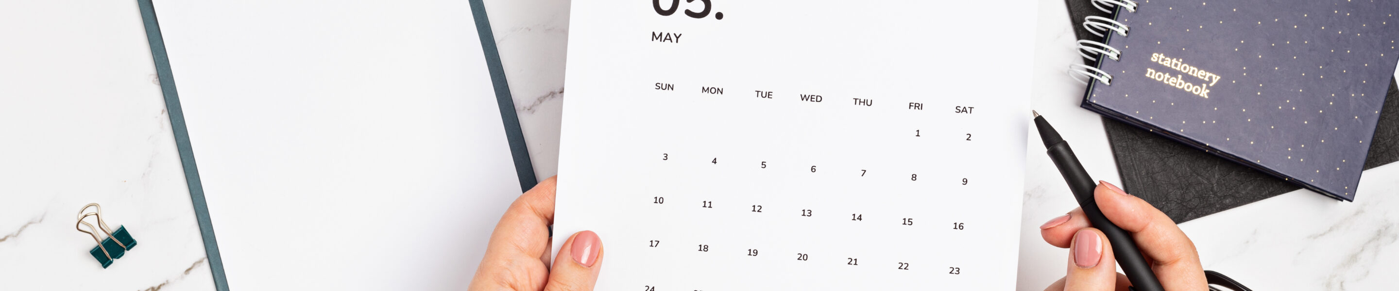 Desktop with calendar for may and office supplies. home office, social media blog, schedule, planning concept. Flatlay, top view