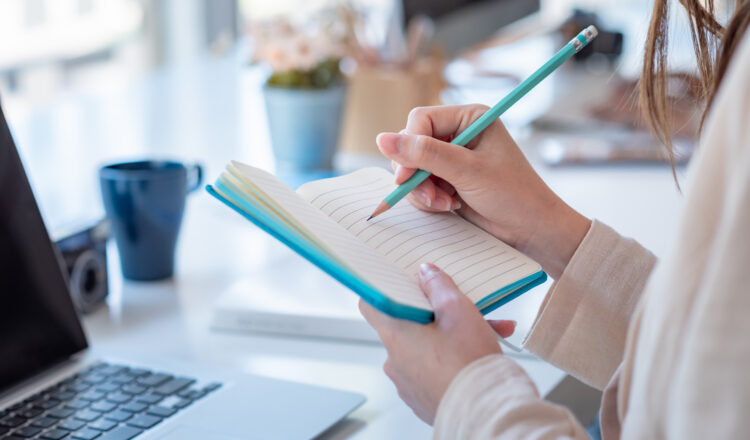 Woman colleg student who taking note online learning at home.