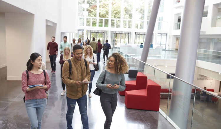 Students walk and talk using mobile devices in university