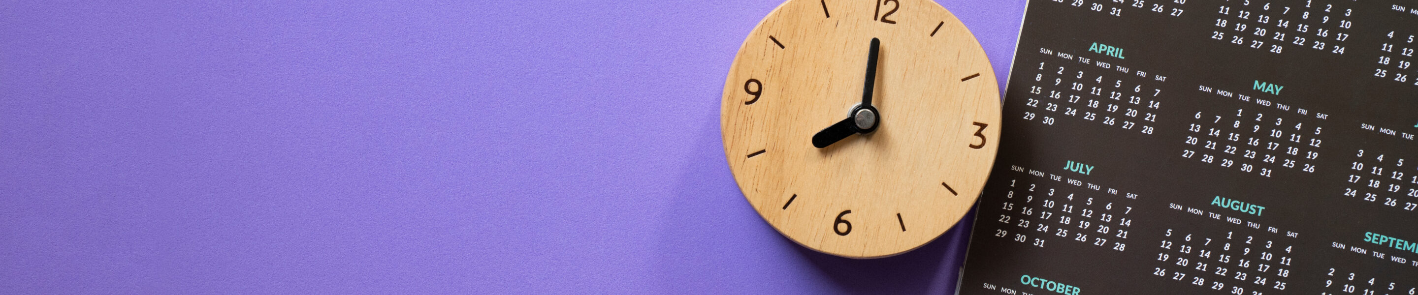 close up of calendar and alarm clock on the purple table background, planning for business meeting or travel planning concept