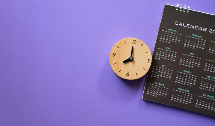 close up of calendar and alarm clock on the purple table background, planning for business meeting or travel planning concept